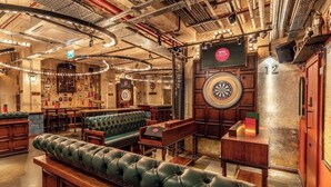 A bar with leather seating, dartboards, and a number 12 sign. - Best location! Shoreditch 5 min walk Old St Tube (London)