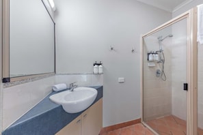 Ein Badezimmer mit Waschbecken, Spiegel und Dusche.