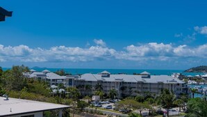A resort with multiple buildings, a marina, and a view of the ocean. - Spa Haven 18B Top Floor In Room Spa (Airlie Beach)