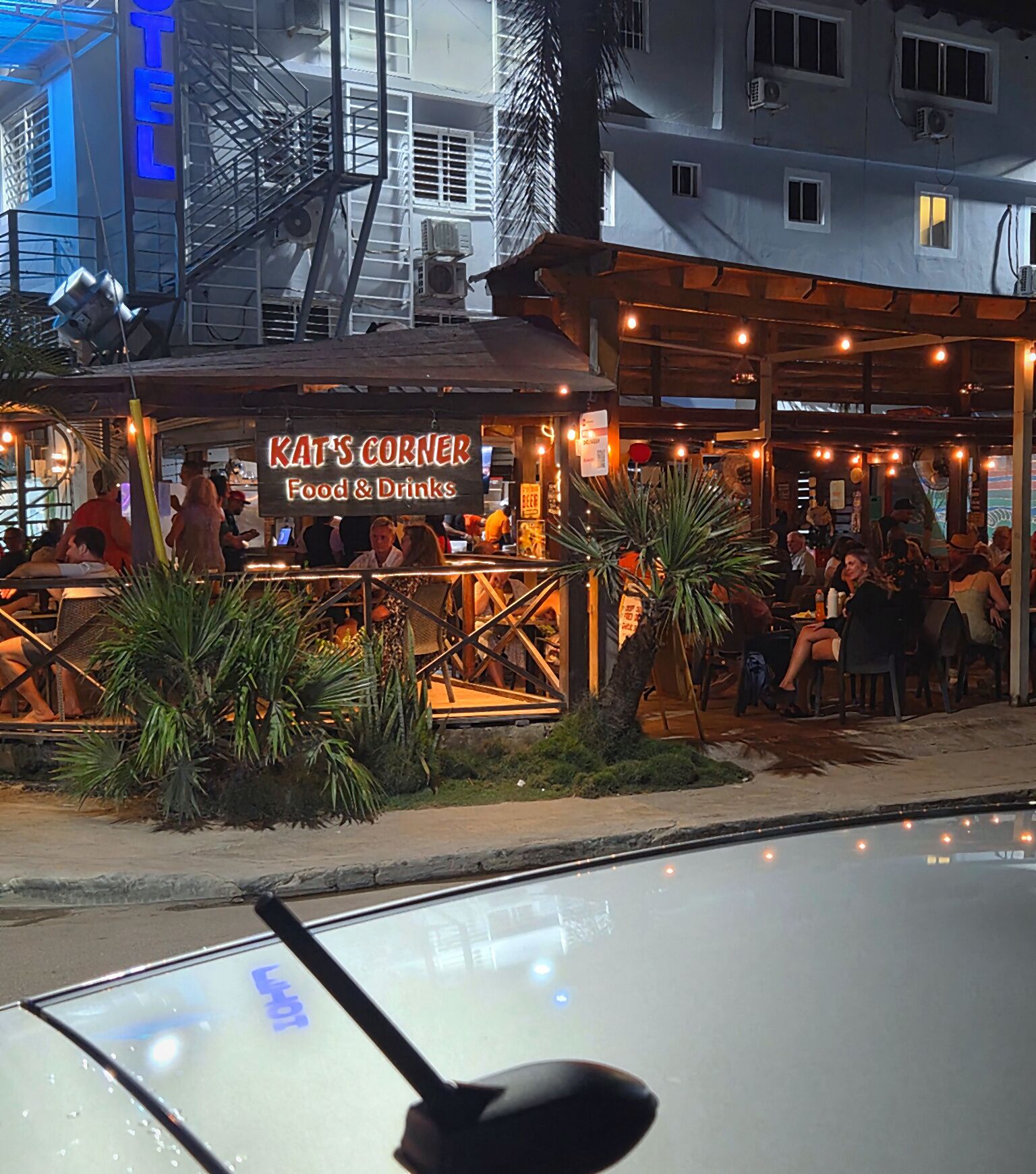 Een restaurant genaamd 'KAT'S CORNER Food & Drinks' met terras en uitzicht op de straat.