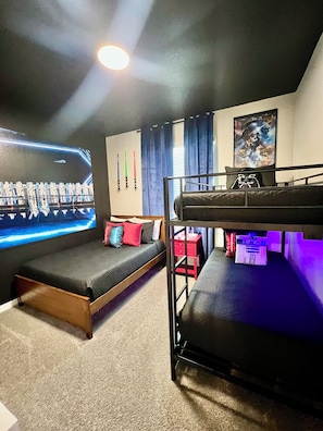 Habitación con literas, un cartel de Star Wars, una pared temática de Star Wars y una almohada temática de Star Wars.