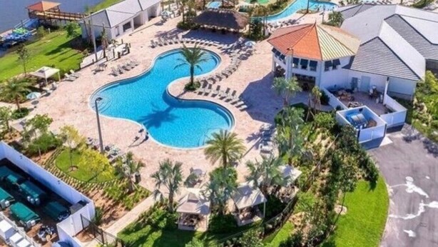 Ein Resort mit mehreren Schwimmbecken, einem großen See und einer gepflegten Anlage.