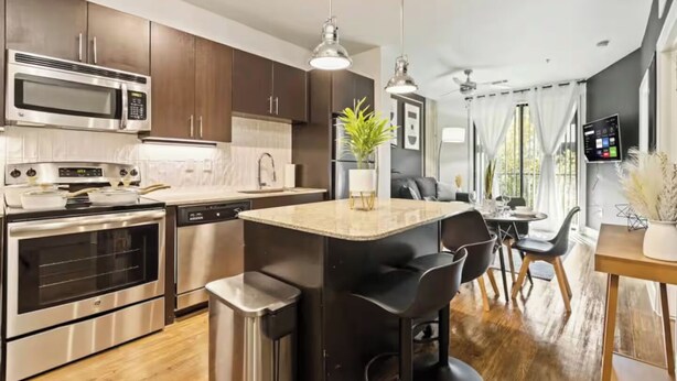 Una cocina moderna con electrodomésticos de acero inoxidable, una isla central y un comedor con vistas.
