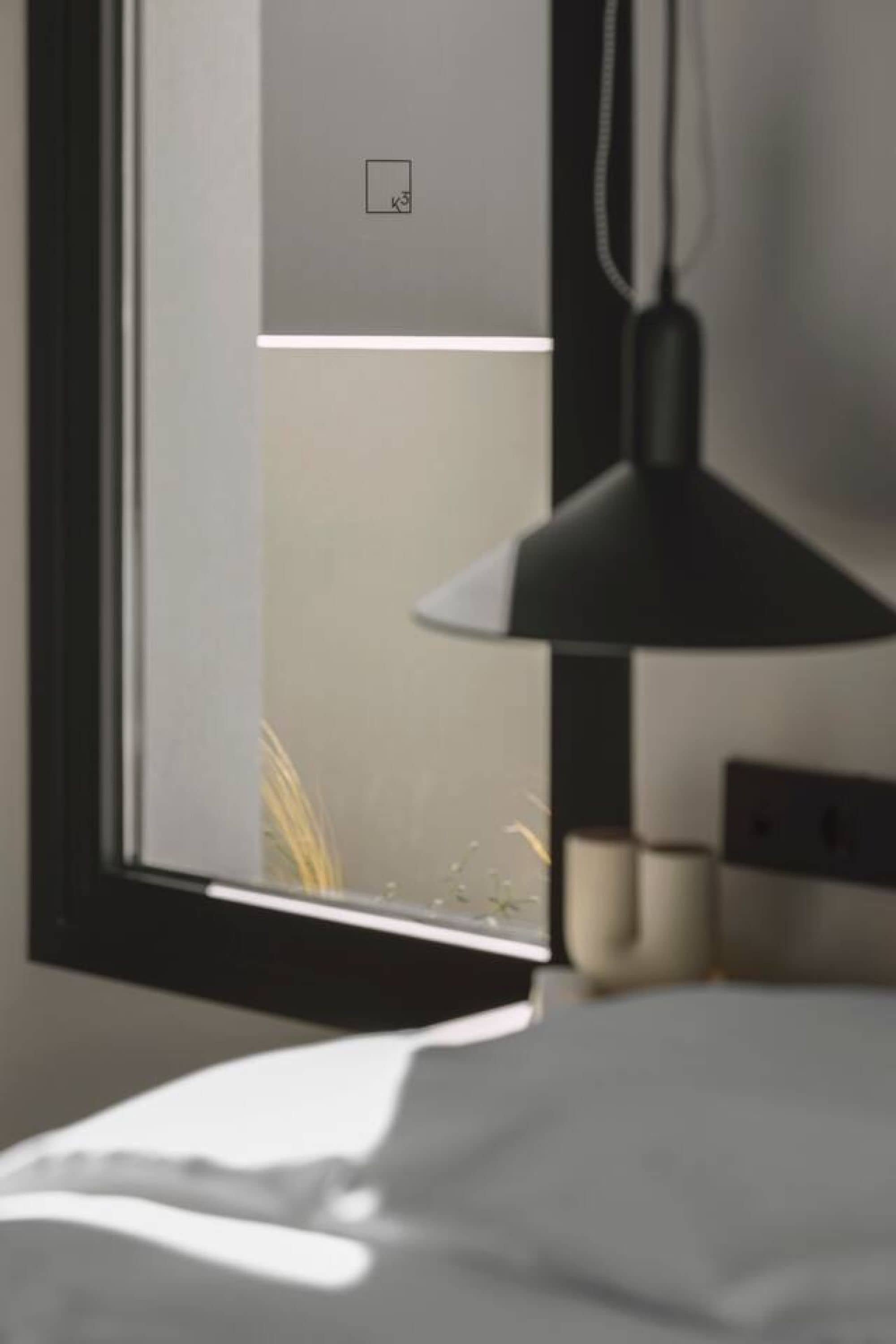 Een kamer met een bed, een raam en een lamp.