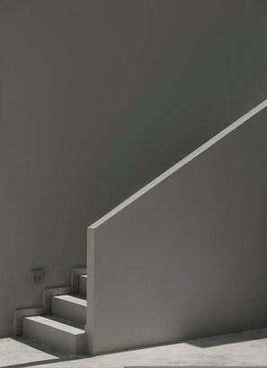 A modern staircase with a minimalist design, leading up to a landing. - Aposperia Memorable Living K3 (Karpathos)