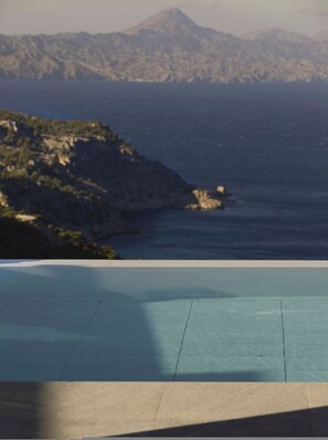 A coastal landscape with a mountainous backdrop and a clear blue sky. - Aposperia Memorable Living K2 (Karpathos)