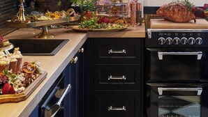 A kitchen with a black and white checkered floor, a built-in oven, and a sink with a gold faucet. - Escape to La Belle Maison, a Tranquil 3 Bedroom villa in central Tauranga. (Tauranga)