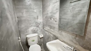 A bathroom with a toilet, sink, and mirror. - Znap Khaosan (Bangkok)
