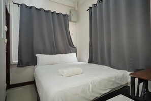 A single bed with white bedding, grey curtains, and a white pillow. - Znap Khaosan (Bangkok)
