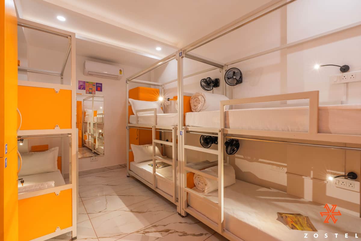 Camera con letto a castello, armadio con specchio e un piccolo tavolo con un libro.