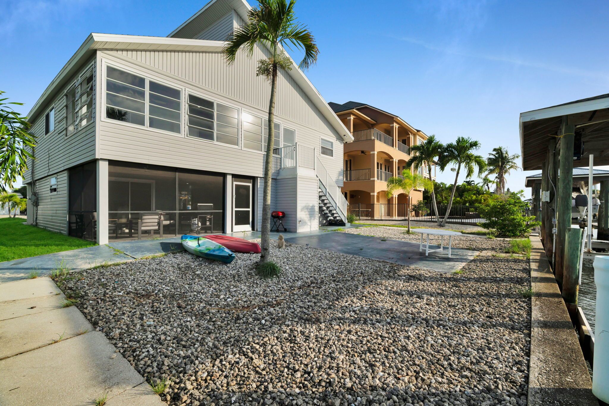 A two-story building with a covered patio area, a staircase leading to the upper level, and a small pool.