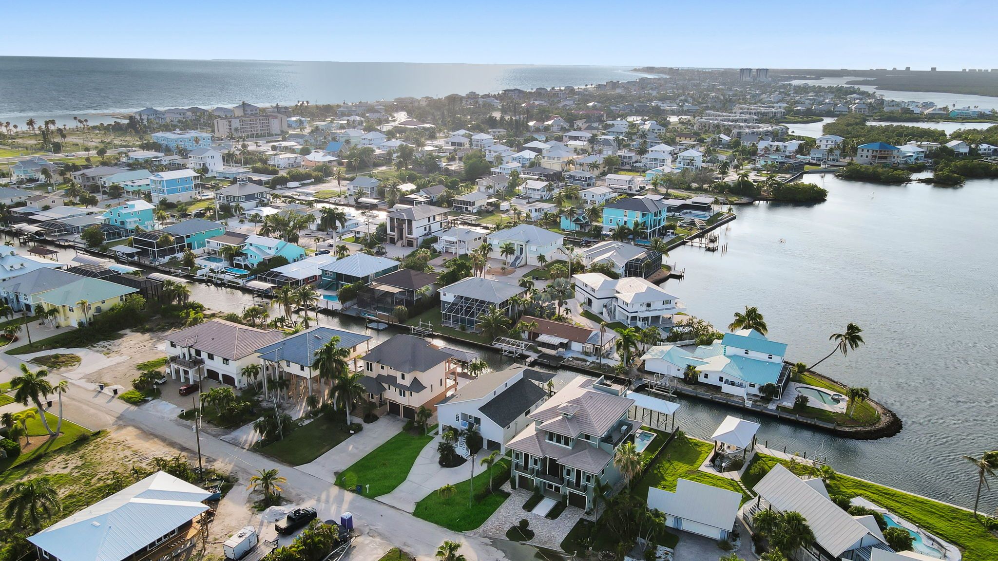 A coastal residential area with houses, a marina, and a view of the ocean.