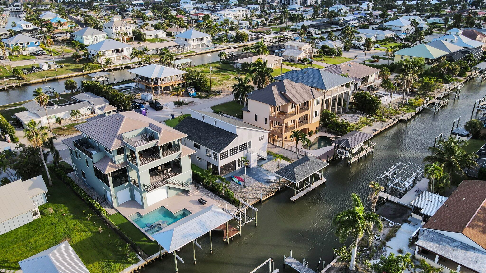 A waterfront property with multiple buildings, a dock, and a swimming pool.