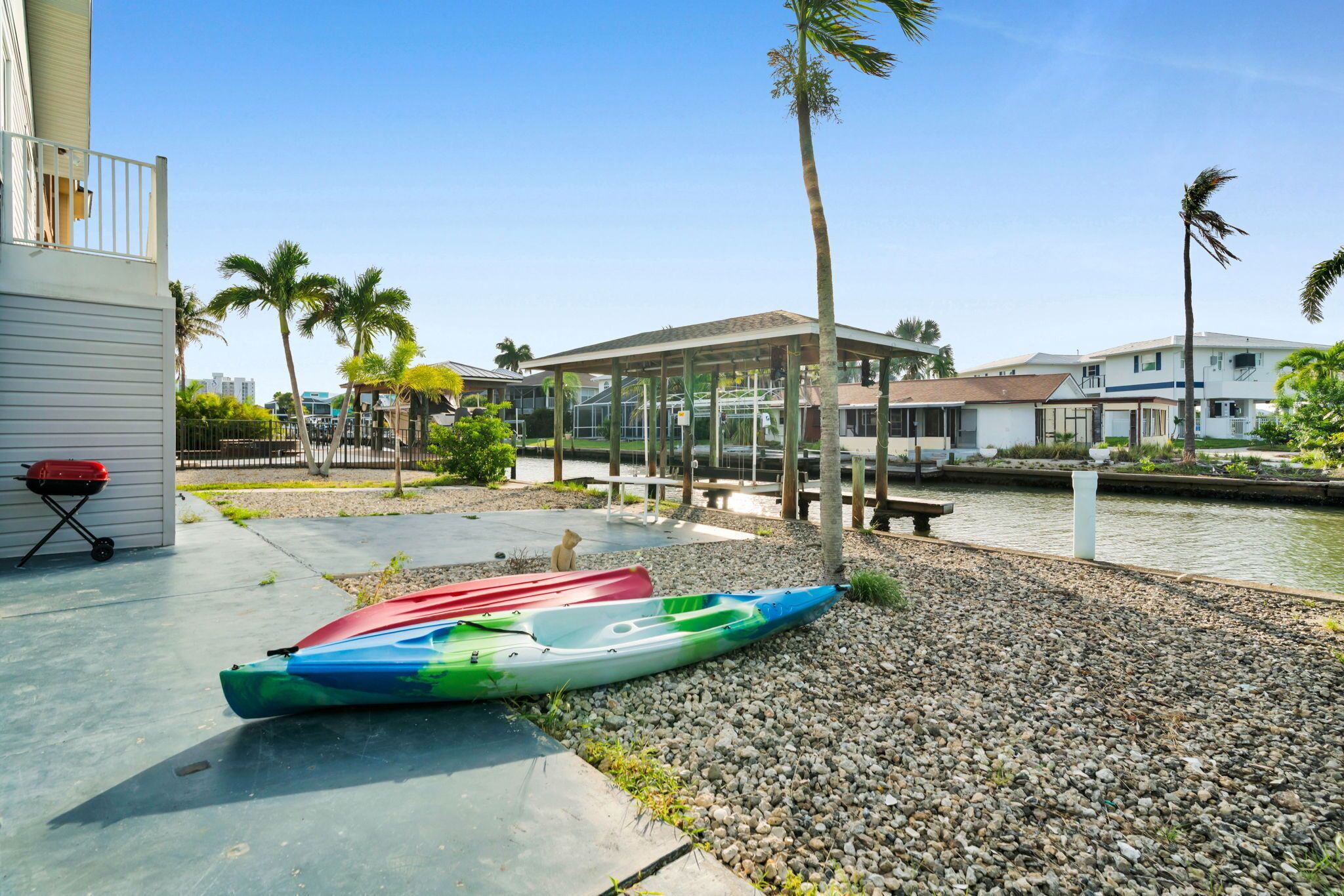Une propriété située au bord de l’eau, dotée d’un patio couvert, de kayaks et d’un barbecue.