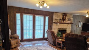 A living room with a fireplace, a large rug, and a brown sofa.