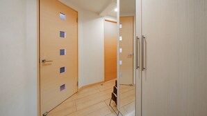 A hallway with wooden doors and a mirrored wall. - E-US NAEBO STATION 102 (Sapporo)