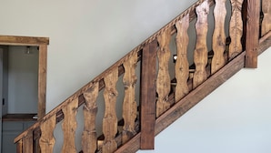 Una escalera de madera con un diseño singular en la barandilla.