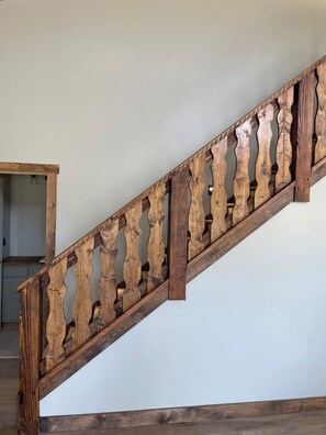 Una escalera de madera con un diseño singular en la barandilla.
