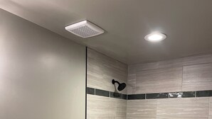 Un baño con inodoro, bañera y cabezal de ducha.