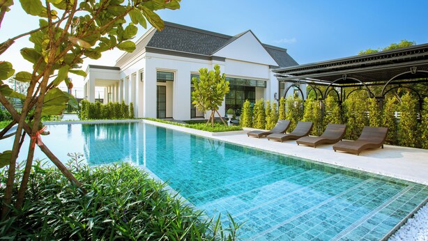 A modern house with a swimming pool, lounge chairs, and a pergola. - Paradhevi Boutique (Ban Dung)