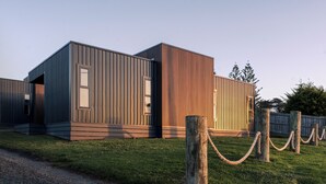 A modern building with a flat roof and a wooden facade. - Style, space & comfort in the heart of Currie (Currie)