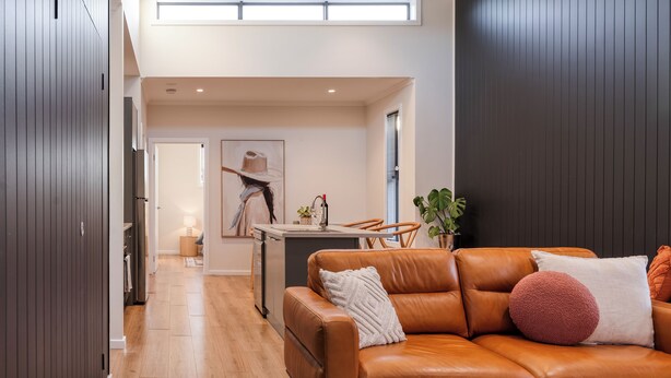 A modern living room with a leather sofa, a dining area with a table and chairs, and a kitchen in the background. - Style, space & comfort in the heart of Currie (Currie)