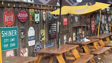 Holzpicknicktische im Freien mit einem Schild für Shiner City Limit, gegründet 2069.