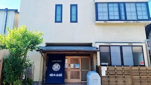 A two-story building with a sign indicating it is a guest house.