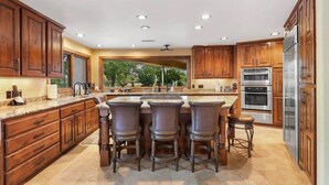 A spacious kitchen with a central island, wooden cabinets, and stainless steel appliances. - Waterfront Clubhouse at Antelope Hills (Prescott)