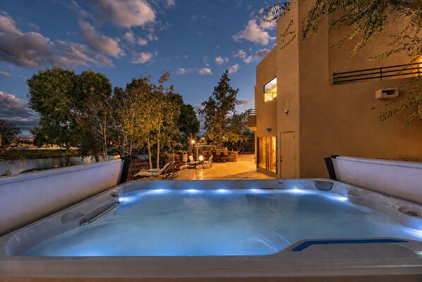 A hot tub with a view of a building and trees.