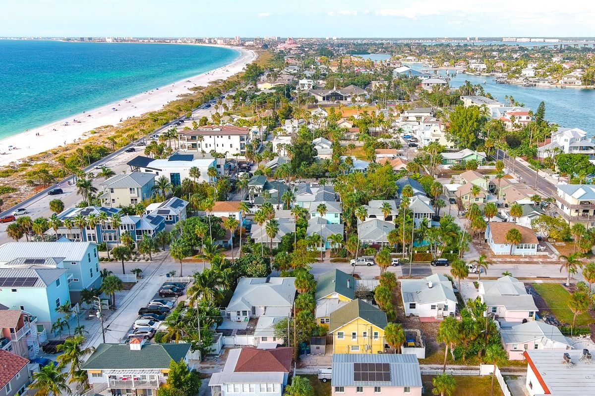 A coastal residential area with houses, a beach, and a marina.