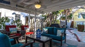 Eine Terrasse im Freien mit Sitzgelegenheit, Deckenventilator und einem Schild mit der Aufschrift 'BIERGARTEN'.