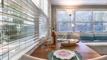 Un comedor con una mesa de madera, sillas y una ventana con persianas.