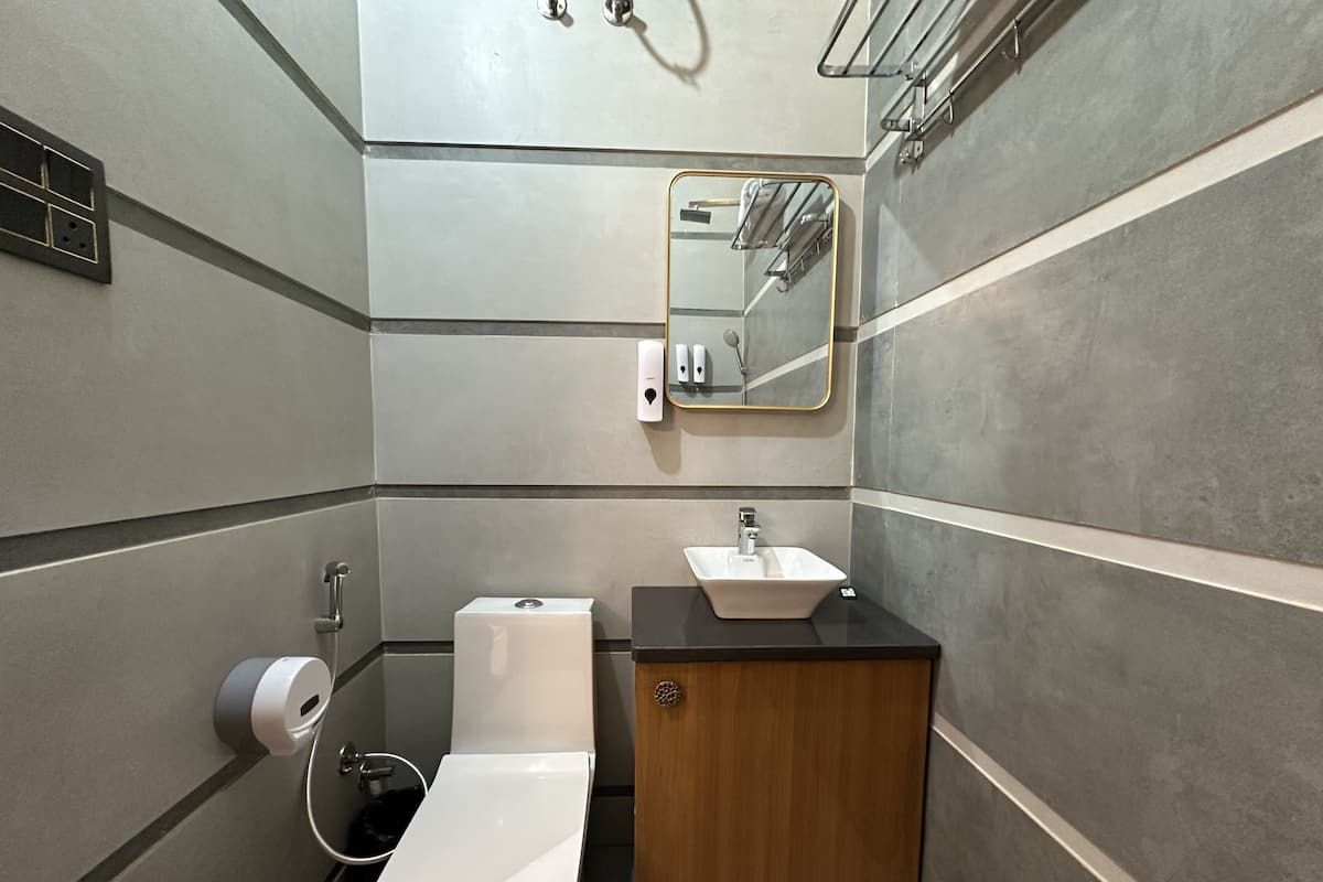 A modern bathroom with a toilet, sink, and mirror.