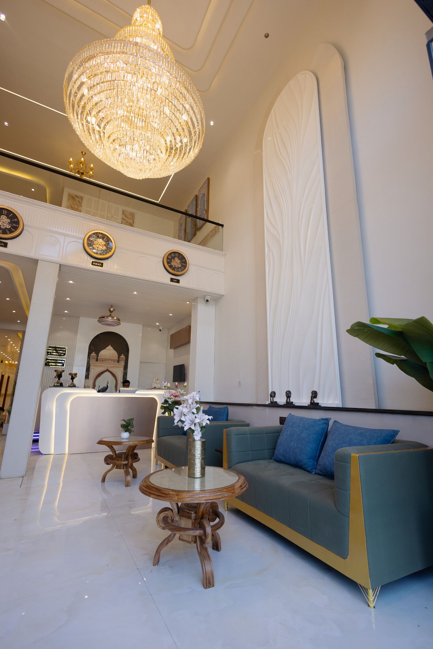 A spacious lobby with a chandelier, a reception desk, a sofa, and a coffee table.
