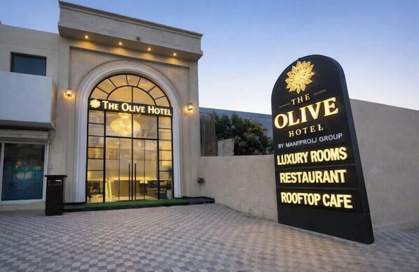 The Olive Hotel with a signboard listing amenities including luxury rooms, a restaurant, and a rooftop cafe. - The Olive Hotel Karnal (Karnal)