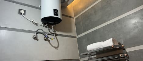A bathroom with a white heater, towel rack, and a mirror.