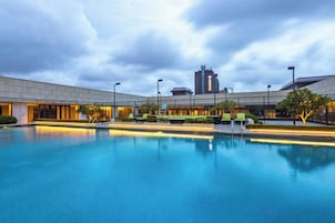 Una piscina con un edificio al fondo.