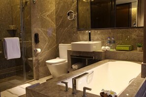 A modern bathroom with a glass shower enclosure, a toilet, a sink, and a bathtub. - Wyndham Jinjiang (Jinjiang)