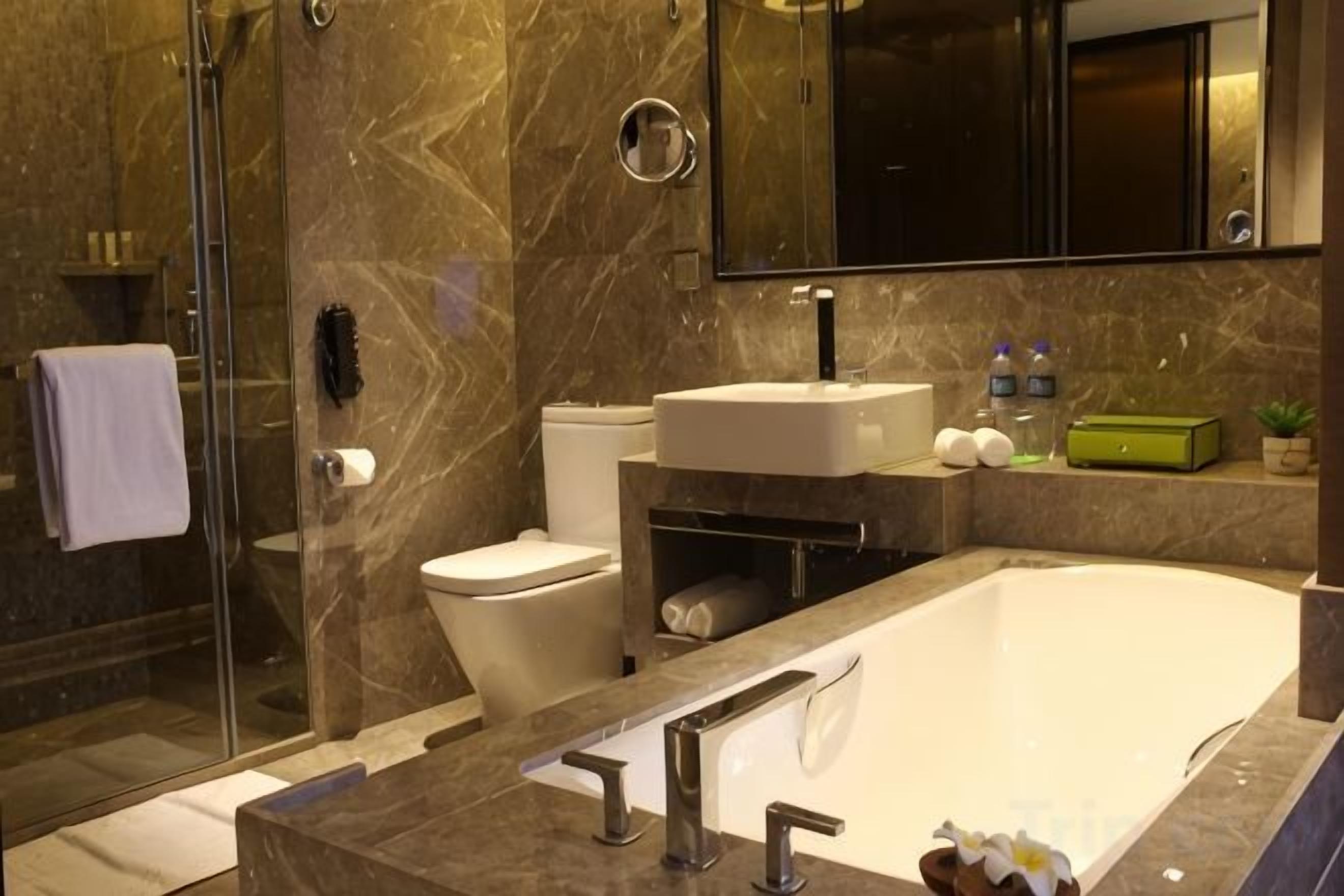 Un baño moderno con cabina de ducha de vidrio, inodoro, lavabo y bañera.