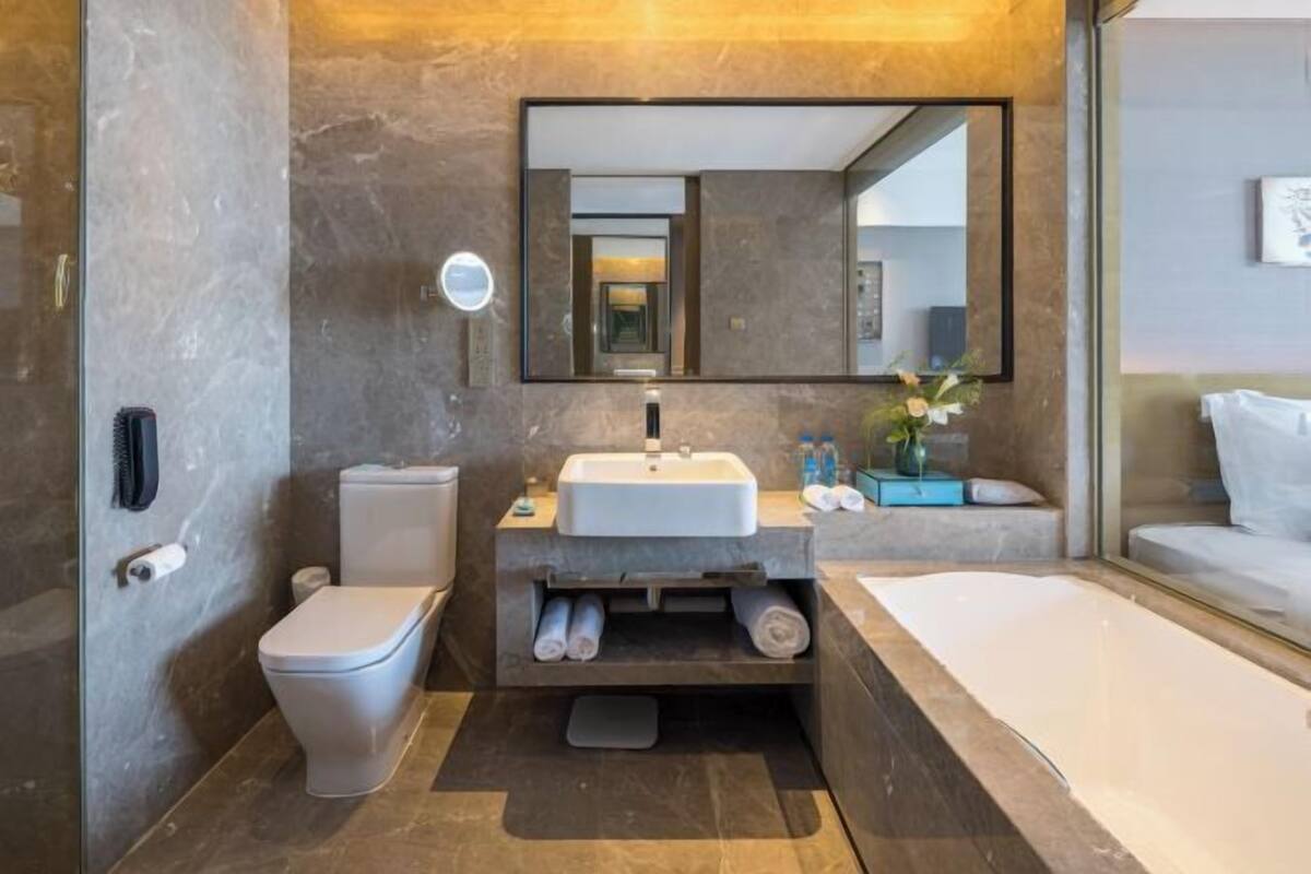 A modern bathroom with a toilet, sink, and bathtub.