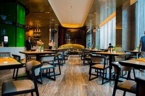 Ein geräumiges Restaurant mit hohen Decken, moderner Einrichtung und einem zentralen Sitzbereich.