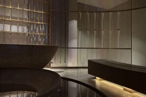 A modern interior with a curved bench, a large bowl, and a wall with vertical slats. - Wyndham Jinjiang (Jinjiang)