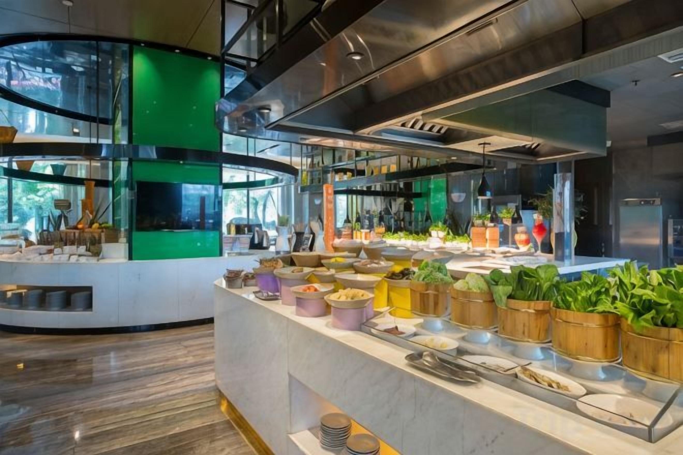 A modern kitchen with a central island, stainless steel appliances, and a variety of food items displayed.