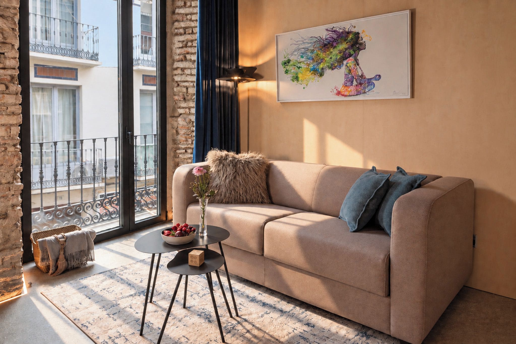 Ein modernes Wohnzimmer mit einem beigen Sofa, einem kleinen runden Tisch und einer Vase mit Blumen.