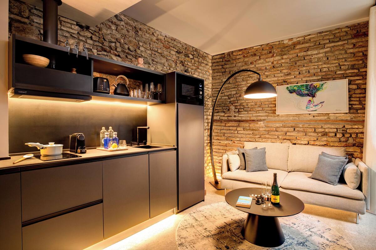 A modern kitchen with a stone wall, a sofa, and a coffee table.