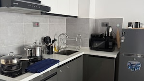 Une cuisine moderne équipée d’appareils électroménagers en acier inoxydable, d’un four à micro-ondes et d’un réfrigérateur.