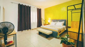 A room with a bed, a fan, a bench, a plant, and a ladder. - THE TERRACE TOWNOUSE, a Creative Escape in the Heart of Kigali (Kigali)