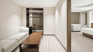 A modern hotel room with a white sofa, a wooden table, a mirror, and a built-in closet. - Lanting Hotel (Danyang)