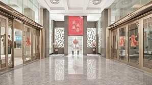 A hotel lobby with a polished marble floor, traditional decor, and a prominent red banner. - Lanting Hotel (Danyang)